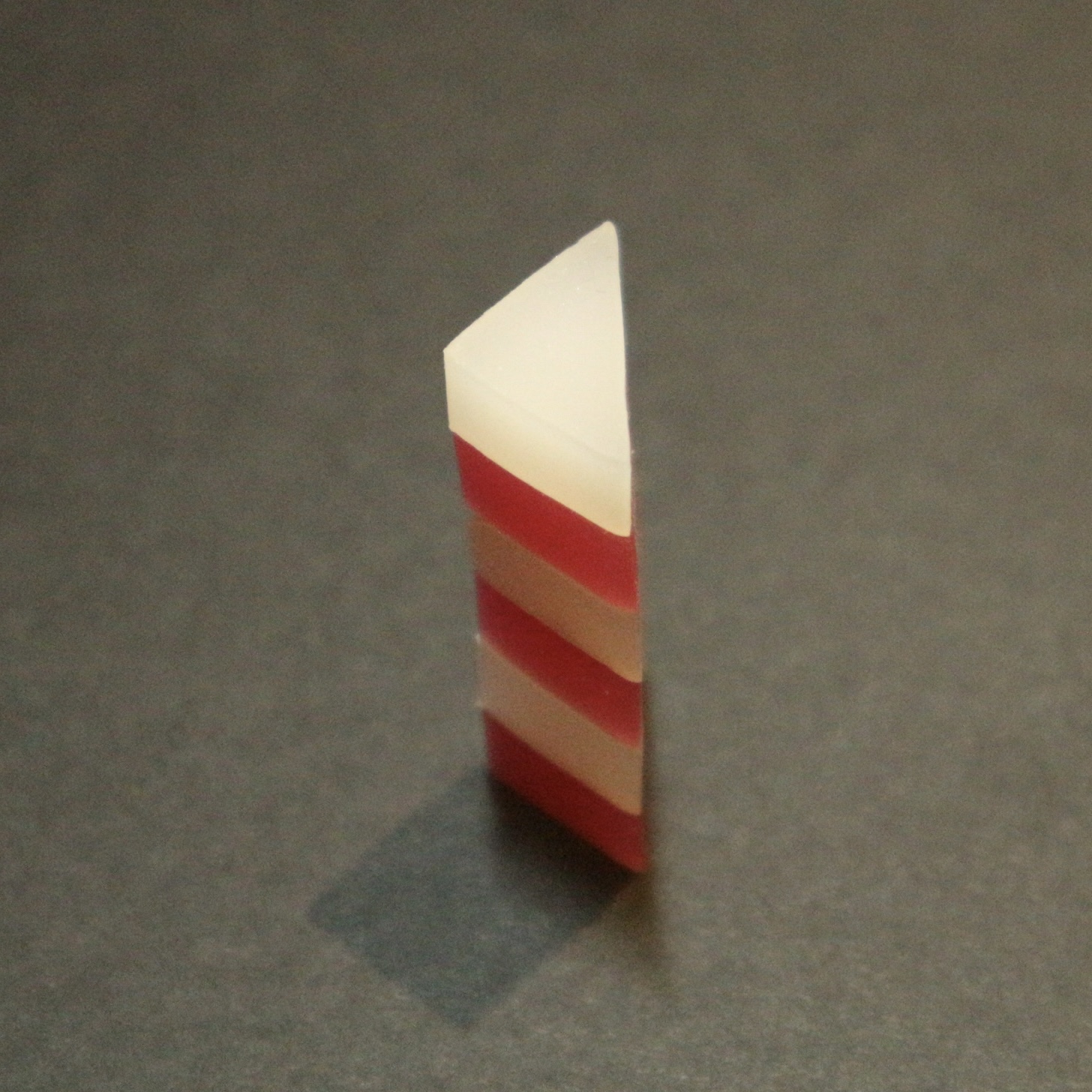 pink and white triangular prism shape erasers being stacked up